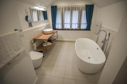 La salle de bains est pourvue d'une baignoire, de toilettes et d'un lavabo. dans l'établissement Villa Campana, à Siófok