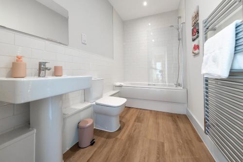 Baño blanco con lavabo y aseo en Apartment 1 Isabella House, Aparthotel, By RentMyHouse, en Hereford