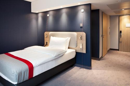 a bedroom with a bed with a black wall at Holiday Inn Express Oberhausen by IHG in Oberhausen
