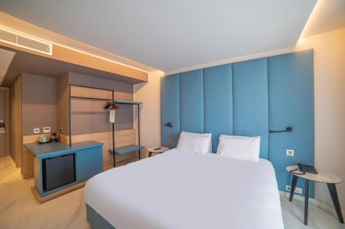 a bedroom with a large bed and a blue wall at Mercure St. Julian's Malta in St Julian's