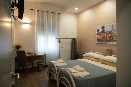 Schlafzimmer mit einem Bett, einem Schreibtisch und einem Tisch in der Unterkunft LECCE MON AMOUR B&B in Lecce
