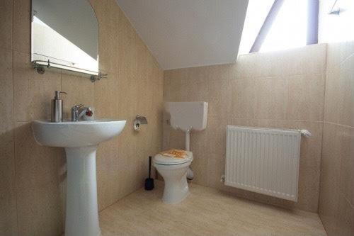 ein Bad mit einem Waschbecken, einem WC und einem Fenster in der Unterkunft Pensiunea Waldhaus - Vatra Dornei in Vatra Dornei