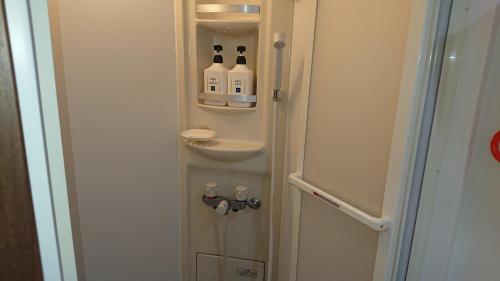 a bathroom with a door with bottles in it at Wajimaya Ryokan in Kyoto