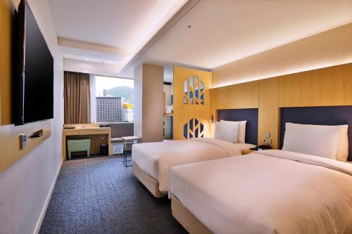 首爾的住宿－Hotel Midcity Myeongdong，酒店客房设有两张床和一台平面电视。