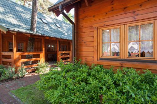 a log cabin with windows on the side of it at Angela Domki i Pokoje in Pobierowo
