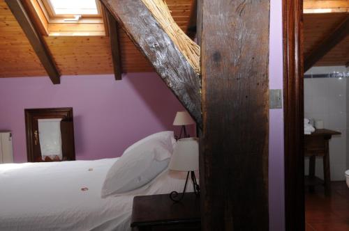 a bedroom with a white bed with a wooden ceiling at Bekoabadene in Menaka