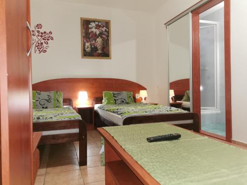 Habitación de hotel con 2 camas y espejo en Penzión Rudolf en Prievidza