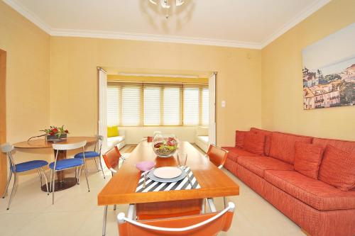 a living room with a red couch and a table at Cosy Bedrooms Guest House in Lisbon