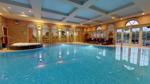 a large swimming pool in a building with a large pool at Grosvenor Pulford Hotel & Spa in Pulford