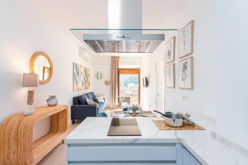 a kitchen with a sink and a living room at Genteel Home Plaza Nueva Granada in Granada