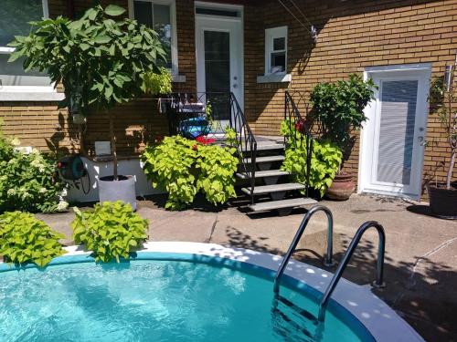 a swimming pool in front of a house at Gîte Chez Baza in Shawinigan