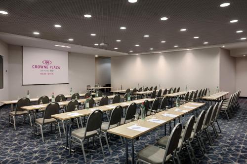 a conference room with rows of tables and chairs at Crowne Plaza Milan Linate by IHG in San Donato Milanese