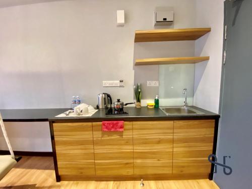 a kitchen with a sink and a counter top at Homesuite' Home at Aeropod SOVO in Kota Kinabalu