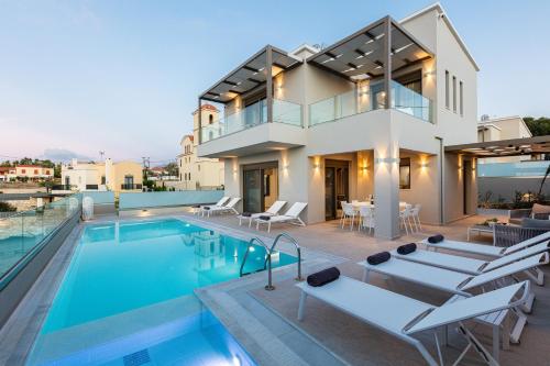 a villa with a swimming pool and a house at Lagoon Seaside Villa, Sumptuous Retreat,By ThinkVilla in Panormos Rethymno