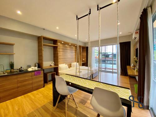 a kitchen and living room with a dining table and chairs at Homesuite' Home at Aeropod SOVO in Kota Kinabalu