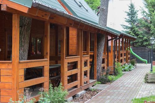 a wooden building with a green slide in a yard at Angela Domki i Pokoje in Pobierowo