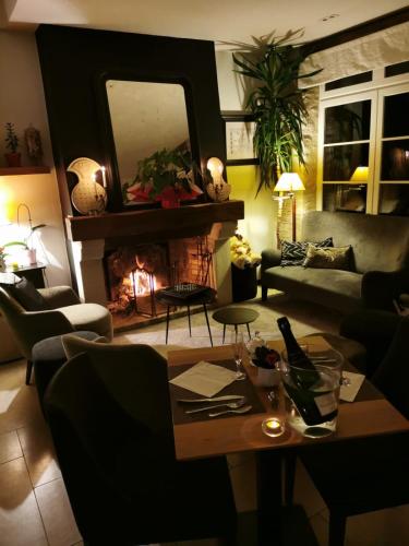 a living room with a couch and a fireplace at Hotel L'Aunette Cottage in Chamant