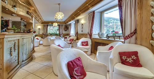 a living room filled with furniture and a large window at Hotel les Sapins in La Clusaz