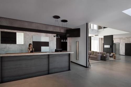 a woman sitting at a counter in a room at J Hotel in Turin