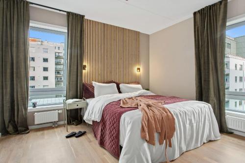 a bedroom with a large bed and a large window at BJØRVIKA APARTMENTS, Teaterplassen, Oslo city center in Oslo