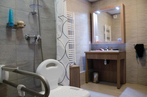 e bagno con doccia, servizi igienici e lavandino. di Résidence Ambroise Paré a Lamalou-les-Bains