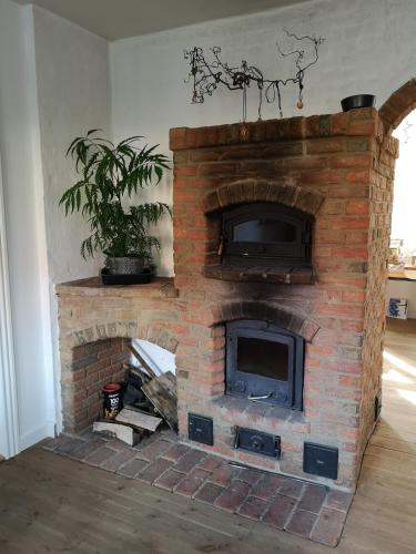 a brick fireplace with a tv on top of it at Safine B&B in Fåborg