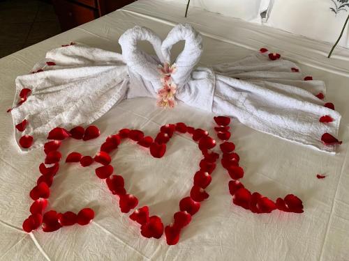 ein Herz aus roten Paprikaschoten auf einem Bett in der Unterkunft Guesthouse Saint Tropez in Arraial do Cabo