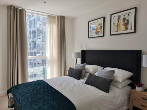a bedroom with a large bed and a window at Canary Wharf by Charles Hope in London