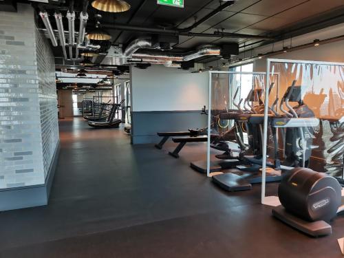 a gym with treadmills and machines in a room at Charles Hope Canary Wharf South Quay in London