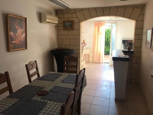 Un comedor con mesa y sillas y una cocina. en Bora, en Béziers