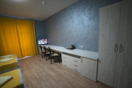 Rivne Hostel في روفنو: غرفة بها مكتب وكراسي في غرفة