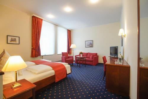 a hotel room with a bed and a television at Strandhotel Ostfriesenhof in Borkum