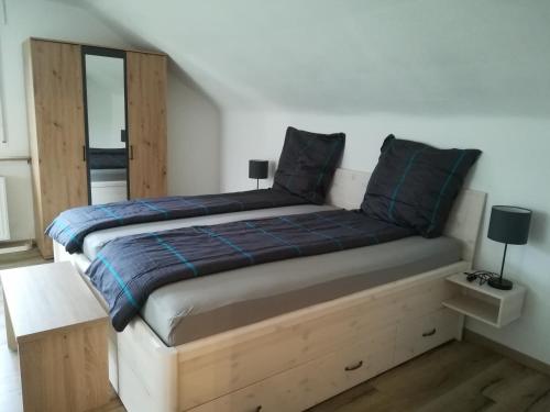 um quarto com uma cama com um cobertor azul e um espelho em El Refugio GD em Schwäbisch Gmünd