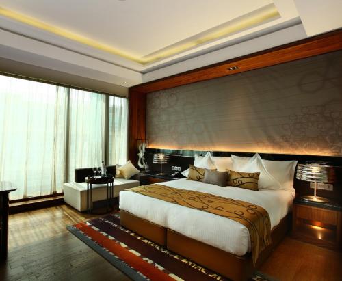 a bedroom with a large bed and a living room at Crowne Plaza New Delhi Rohini by IHG in New Delhi