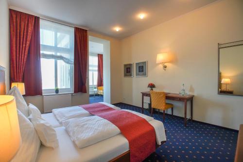 ein Hotelzimmer mit einem Bett und einem Schreibtisch in der Unterkunft Strandhotel Ostfriesenhof in Borkum