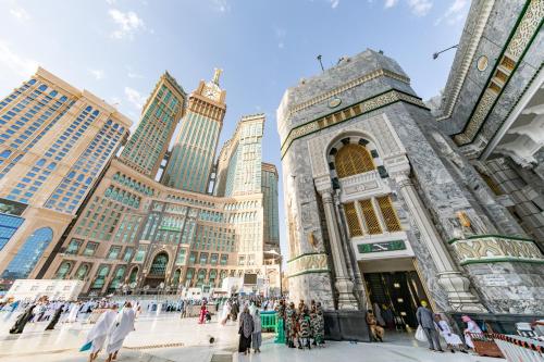 a group of people standing in front of a building at Al Marwa Rayhaan by Rotana - Makkah in Mecca