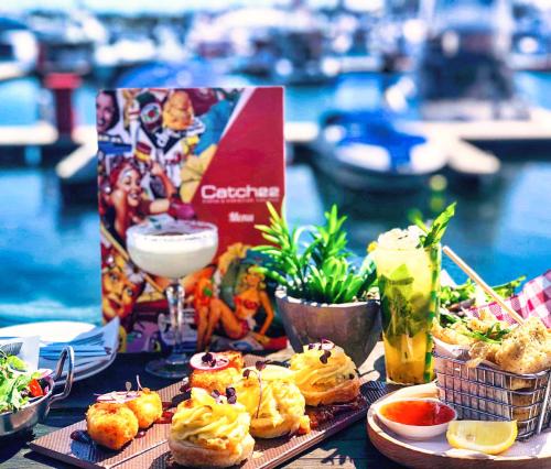 a table topped with appetizers and drinks and food at Marina Canals Apartment in Mandurah