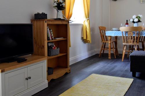 uma sala de estar com uma televisão e uma mesa em Woodlands View em Halesworth