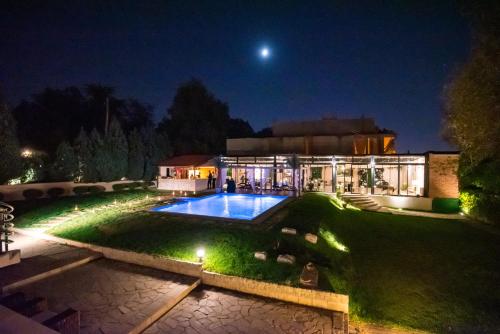 una casa con piscina por la noche en The Belgrade Hills Rooms and Suites, en Belgrado