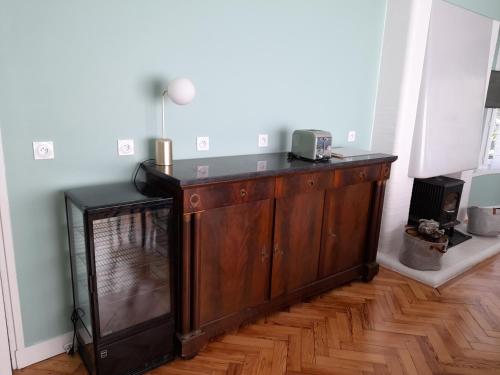 a wooden cabinet in a room with a fireplace at Maison Art Deco-5 suites, piscine, clim, parking in Labouheyre