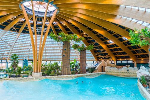 a large swimming pool in a building with a roof at Mobile Homes by KelAir at Camping Domaine des Ormes in Dol-de-Bretagne