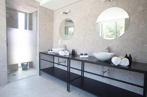 a bathroom with two sinks and two mirrors at Zest Boutique Hotel by The Living Journey Collection in Cape Town