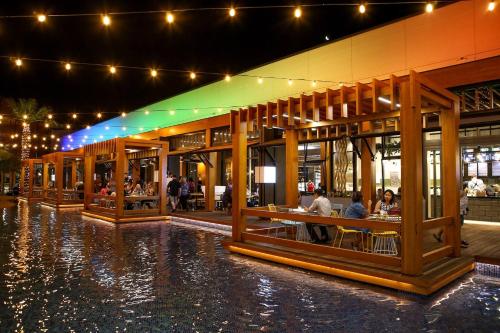 a building with people sitting at tables in the water at Marina Canals Apartment in Mandurah