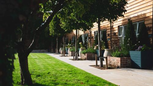a building with a row of benches next to a lawn at The Grosvenor Stockbridge in Stockbridge