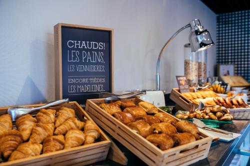 a bakery with baskets of pastries on a counter at ibis Haguenau Strasbourg Nord in Haguenau