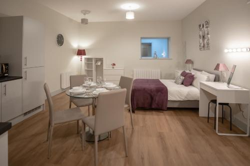 a room with a bed and a table and a bed and a table and chairs at Hereford City Centre - Apartment 2, Isabella House - Modern Apartment In The Heart of The City - Sleeps 2 Guests - Hosted by RENTMYHOUSE in Hereford