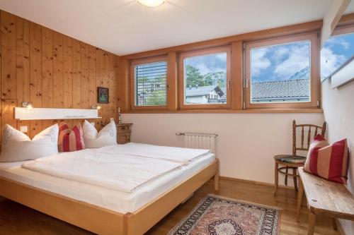 um quarto com uma cama grande e janelas em Försterhaus Wohnung Dachgeschoss em Egg