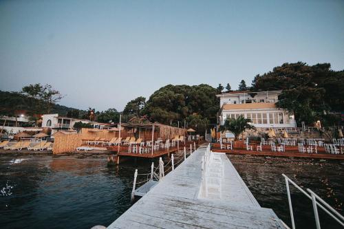 a dock with chairs on the water next to buildings at Büyükada Loc'ada in Adalar