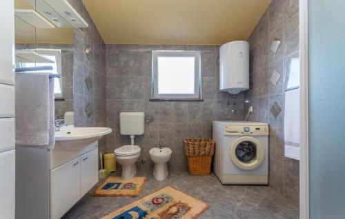 bagno con lavandino e servizi igienici e lavatrice. di Apartman Stela a Poreč (Parenzo)