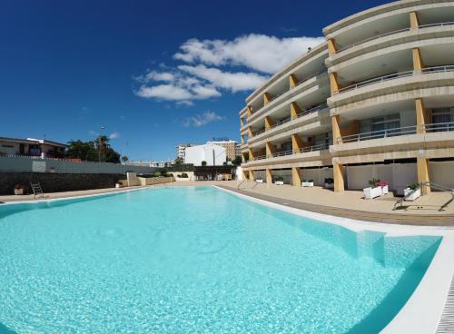 a large swimming pool in front of a building at Apartamentos Montemar in Playa del Ingles